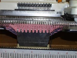 Flat Bed Knitting Machines use a Claw Weight to Hold the Stitches down when Knitting the heel of a sock