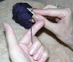 Grasp the free end of the yarn lightly against the left hand with the second, third, and fourth baby finger. This is the yarn that you measured off when you created the slip knot.