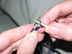 Slip the old stitch off the left needle by pulling the right hand needle to the right.