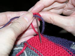 Taking the left end behind the right end yarn, Tuck the left end yarn through the circle bringing it to the front