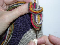 Insert your tool back through the center of the circular loop created in Figure 13 and grab all the yarn ends